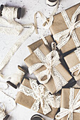 Christmas gifts wrapped in brown paper tied with lace ribbons