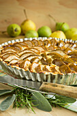 Pear tart in a tart pan on a rustic wooden table