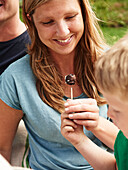 Mother and child eating berry skewers with chocolate coating