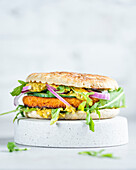 Fish burger with curry sauce, rocket, and red onions