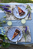 Beerenkuchen und Getränk auf Tisch mit Veronica, Jungfer im Grünen und Hortensie