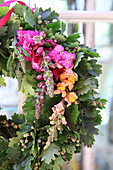 Oak leaf wreath with colorful flowers of snapdragons and Stocks