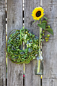 Strauß aus Sonnenblumen und Mohnkapseln in Milchkannen