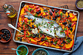 Baked gilthead with pumpkin, peppers, tomatoes, and olives