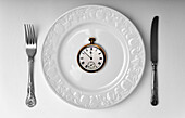 Watch on a plate, conceptual image