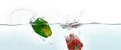 Two peppers splashing in water