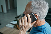 Man with hearing aid using mobile phone