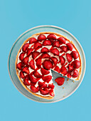 Erdbeerkuchen vor hellblauem Hintergrund