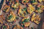 Crispy tray-baked squashed potatoes with wild garlic and rocket pesto
