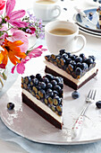 Brownie cake with cream and fresh blueberries in jelly