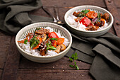 Vegan seitan vegetable stir fry with sweet and sour rice on rice