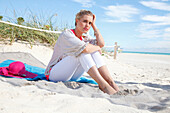 Junge blonde Frau in Freizeitbekleidung am Strand