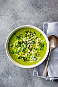 Pea and mint soup with star noodles garnished with grated Parmesan cheese
