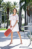 Brunette woman with bag in summer dress with embroidery