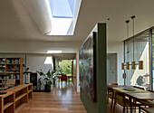 Open living room with green painted room divider and skylight