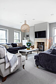 Living room with velvet sofas, marble table and fireplace