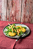 Basil and polenta patties with young vegetables