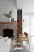 Brick fireplace, leather chairs in front, sofa, and side table in a living room