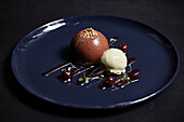 A mini dark chocolate dome served with cherries and ice cream