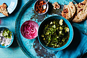 Saag paneer with pickled red onions, mango chutney and garlic naan bread