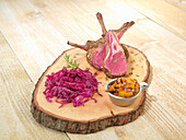 Lamb chops with red cabbage served on a rustic slice of wood