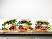 Breakfast sandwiches with fried egg, ham and arugula
