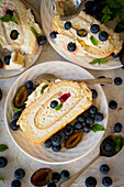 Sponge cake roulade with whipped cream and summer fruits