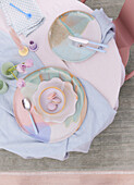 Pastel colored place setting on table with tulips and candle
