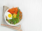 A spicy breakfast with vegetables, grains and a fried egg