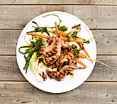 Grilled rabbit with carrots and spring onions