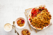 Plum and hazelnut crumble, served with cream topped with ginger powder