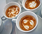 Three cappuccinos with different milk foam patterns