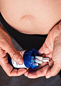 Overweight woman taking pills, conceptual image
