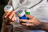 Woman examining several bottle of pills