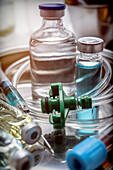 Vials and syringe in a tray metal, conceptual image