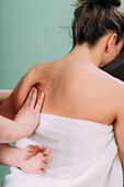 Chair massage therapist massaging woman's back