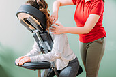 Female employee sitting on a portable massage chair