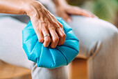 Woman holding an ice pack over a painful knee