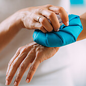 Woman holding ice bag compress on a painful wrist