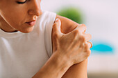 Woman holding onto painful shoulder