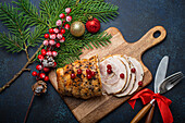 Christmas baked ham sliced with red berries and festive decorations
