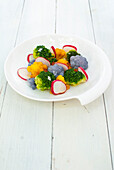 Colorful cauliflower and broccoli florets with golden raisins and radishes