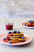 Banana pancakes with raspberry sauce and blueberries
