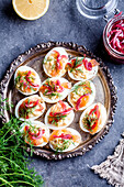 Deviled eggs with salmon, lemon mayonnaise and pickled red onion