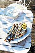 Gegrillte Makrelen mit Zitronensalsa auf  Terrassentisch