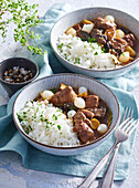 Pork and mushroom stew with pickled onions and rice