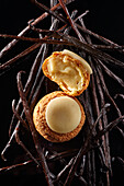 Choux au craquelin pastry with vanilla cream around it Vanilla pods