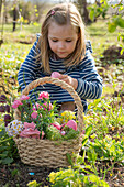 Kleines Mädchen mit Osterkorb im Garten