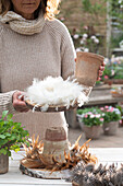 Self-made cake stands with feather wreaths; wooden discs; clay pots; eggs and radish in a pot