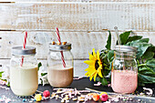Three assorted smoothies in mason jars with straws